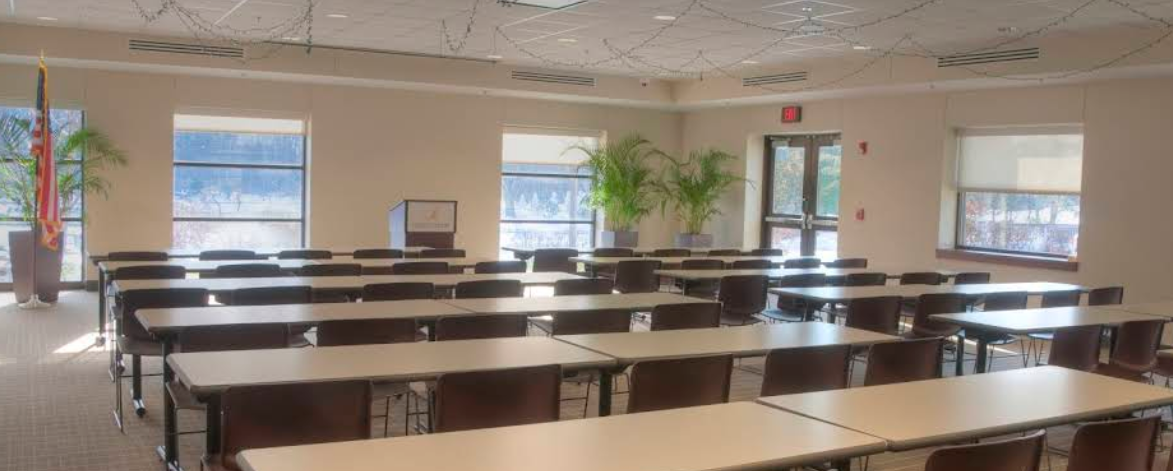 Large meeting room with rows of tables and chairs