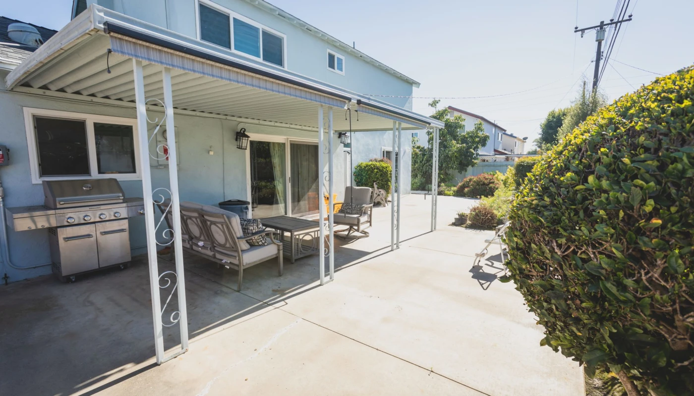Covered patio with seating and barbecue grill