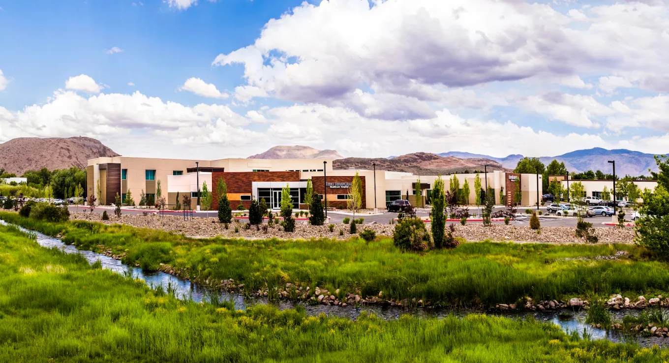 Hospital campus with landscaped grounds and mountain backdrop