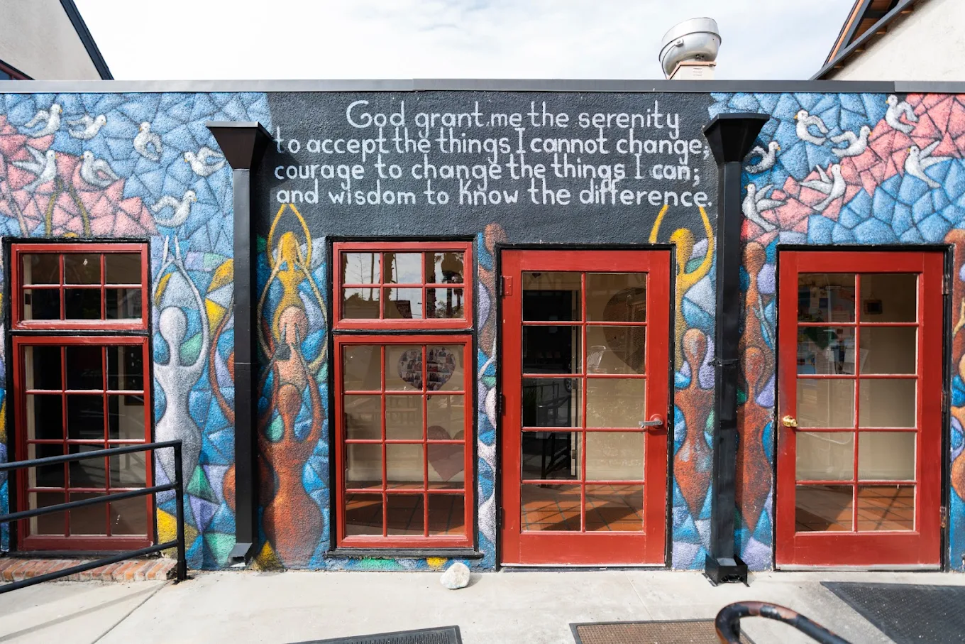 Close-up of colorful mural with serenity prayer and red doors