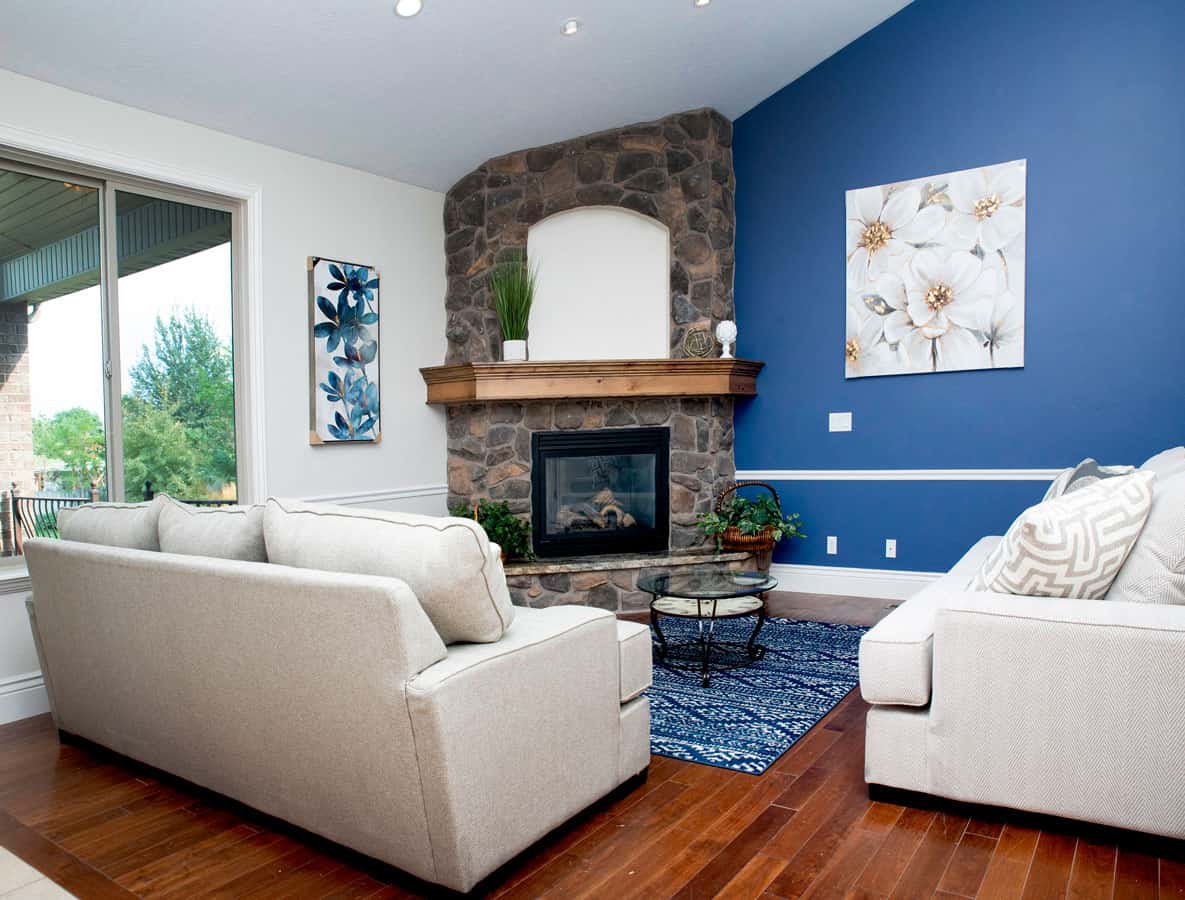 Cozy lounge with stone fireplace and modern white sofas.