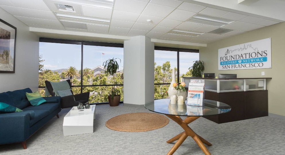 Reception desk and lounge with large windows and city views