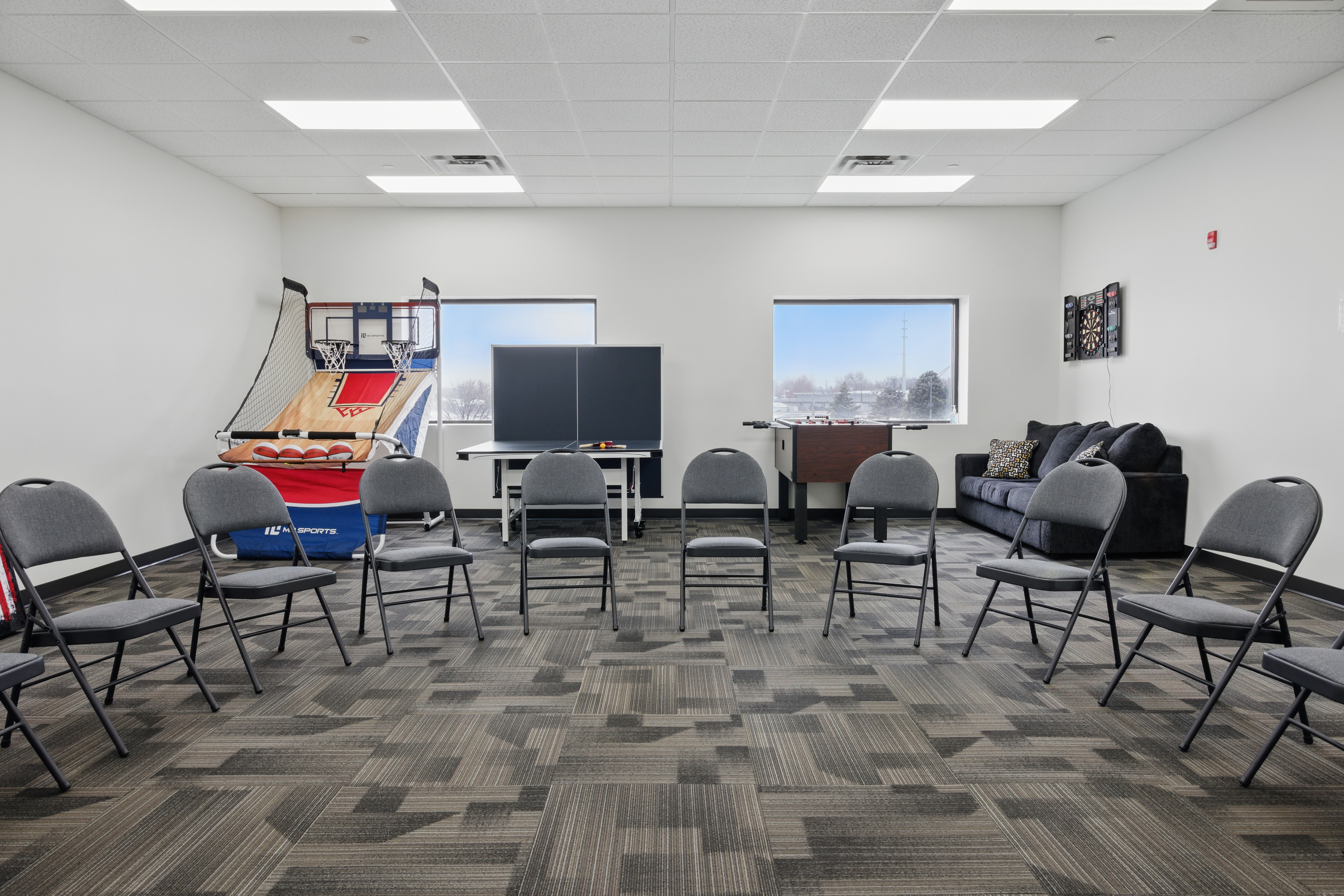 Multi-use room with game tables and therapy chairs
