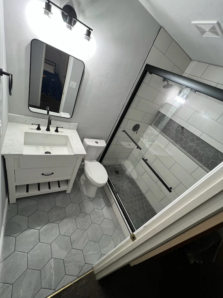 White vanity with glass shower and tile floor