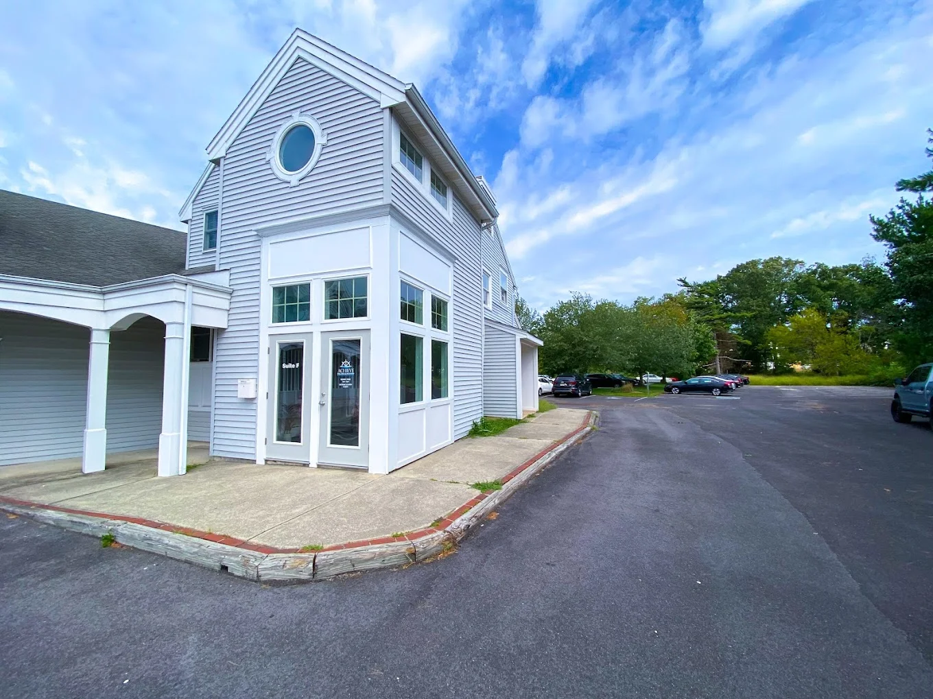 Modern gray building with white trim and parking lot