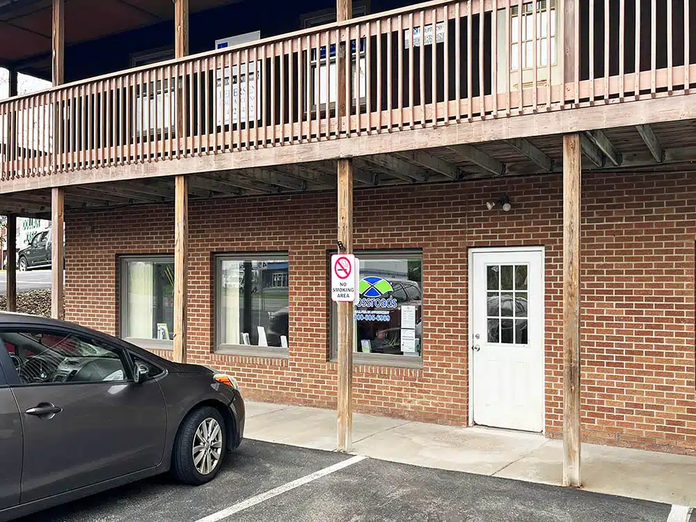 Brick clinic exterior with covered walkway and parked car