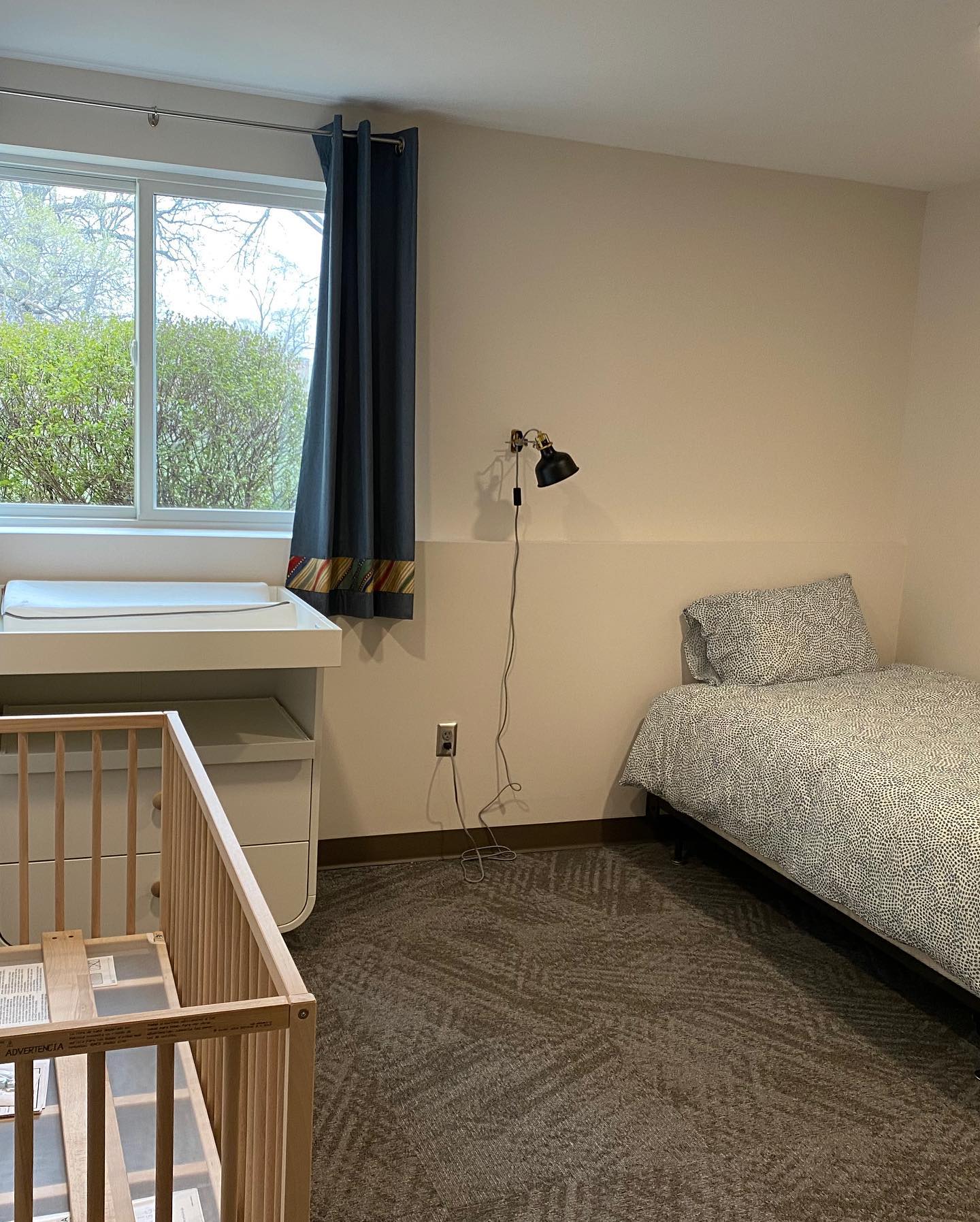 Room with crib, changing table, single bed, and window