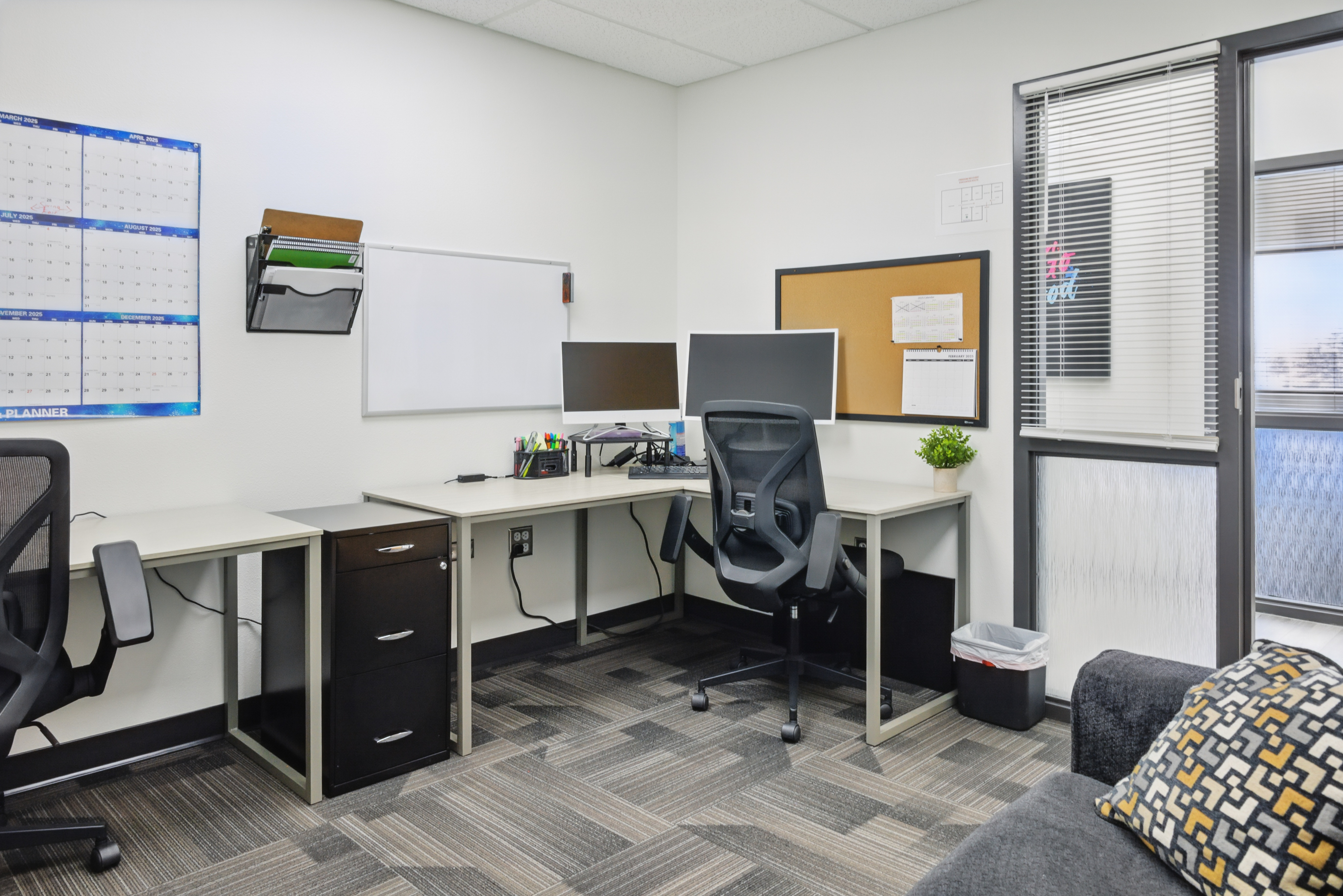 Shared workspace with L-shaped desks and monitors
