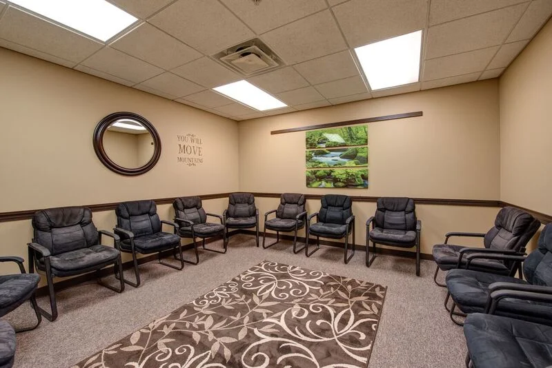 Meeting room with cushioned chairs arranged along the walls
