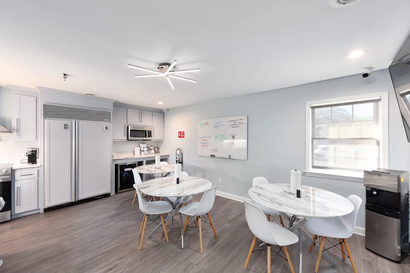 Dining area with round tables, chairs, and kitchenette
