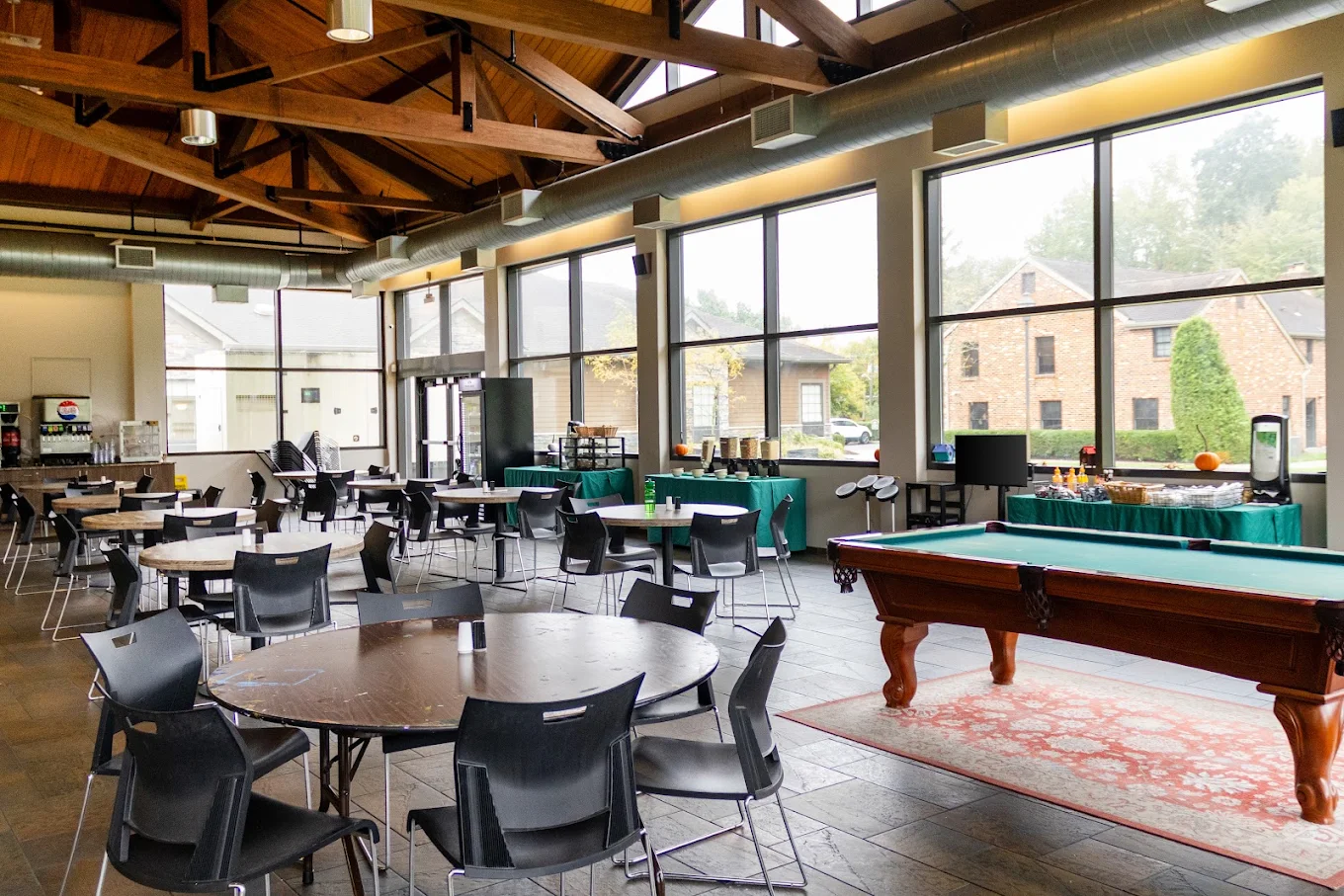 Recreation room with pool tables, seating, and large windows