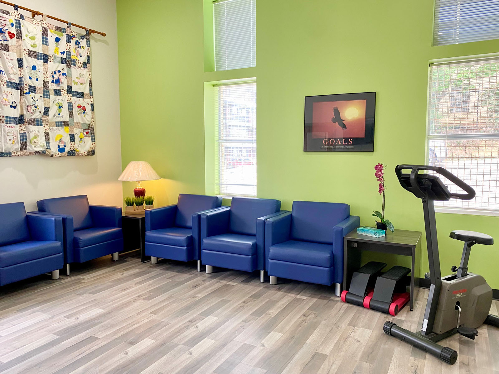 Lounge with blue armchairs, TV, and exercise bike