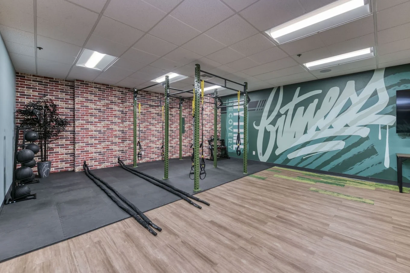 Indoor gym with equipment and fitness mural