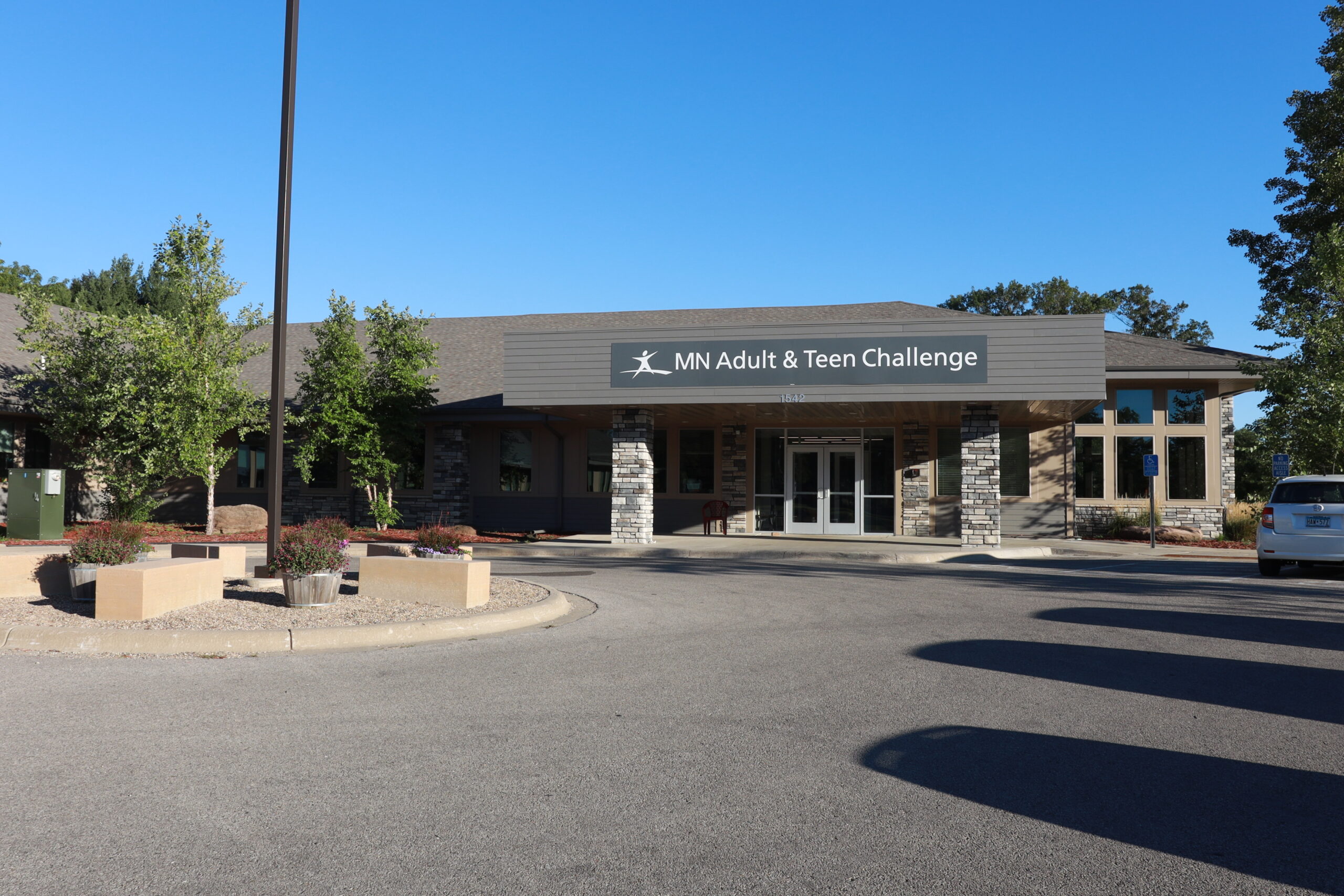 Facility entrance with stone columns and MN Adult & Teen Challenge sign