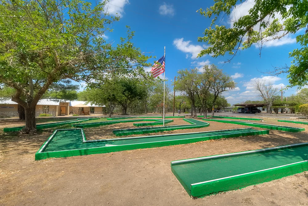Outdoor miniature golf course surrounded by trees
