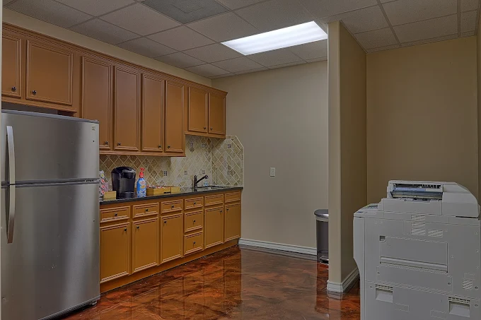 Kitchen area with cabinets, fridge, and counter