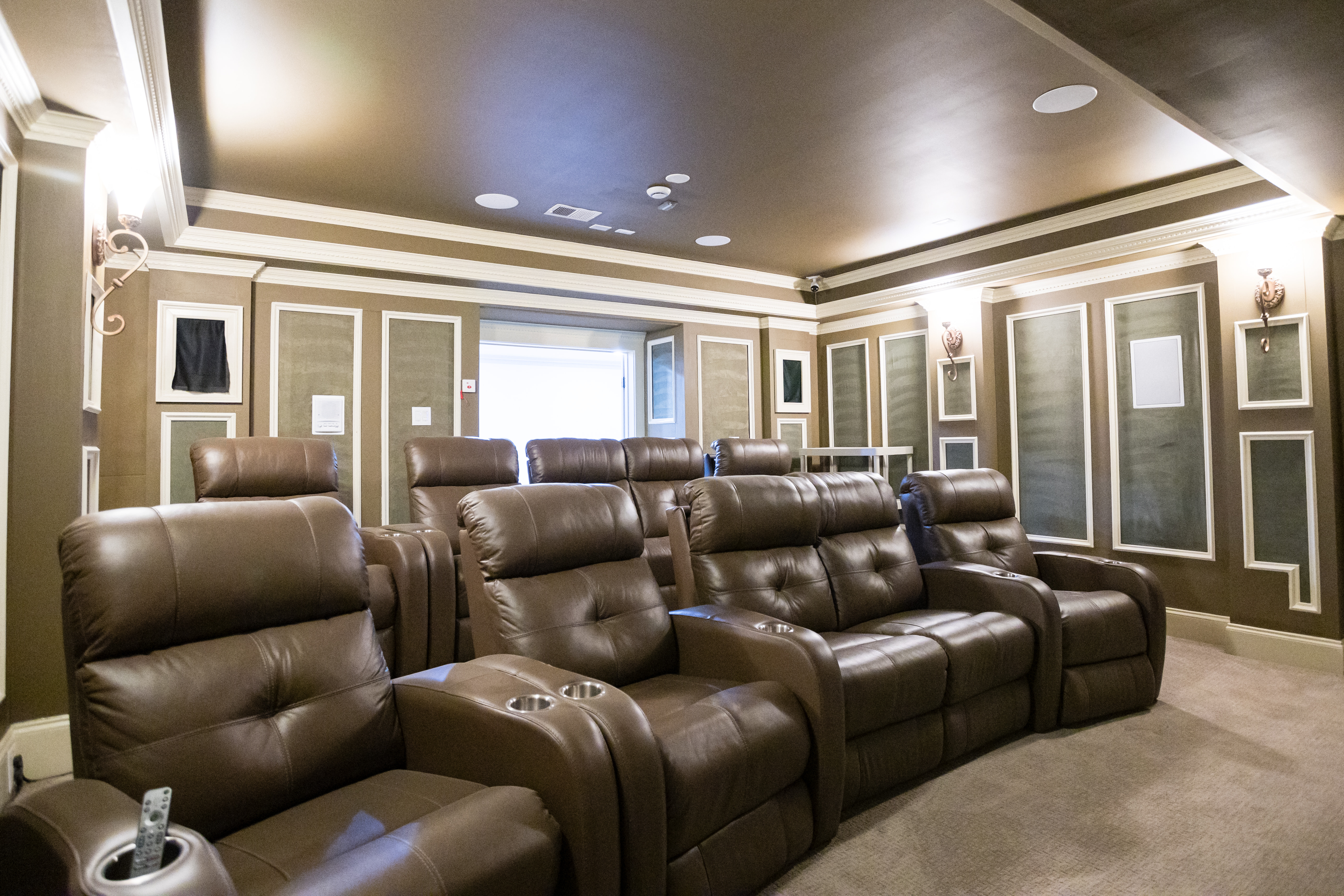 Theater room with brown leather recliners and dim lighting