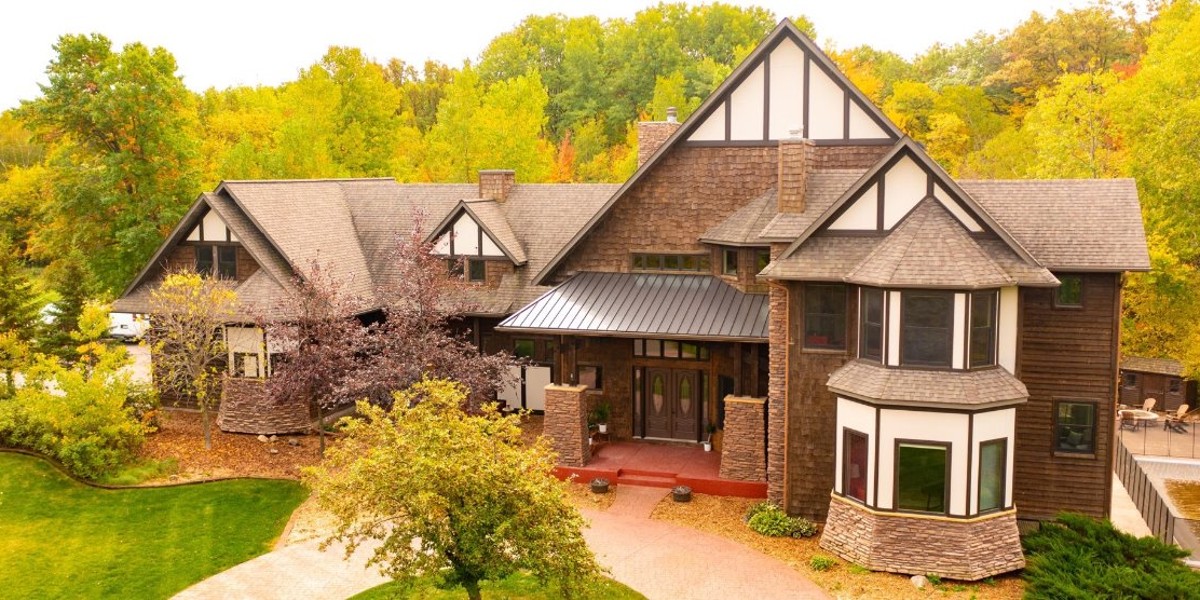 Large house surrounded by colorful fall trees