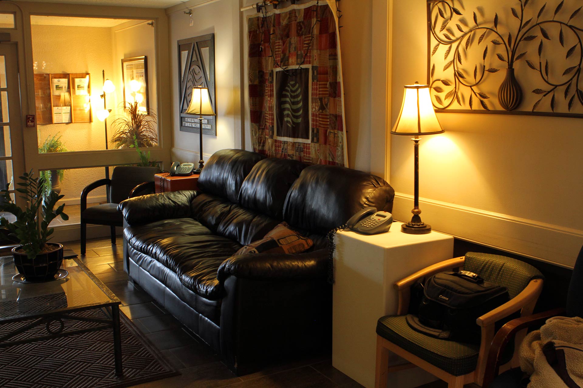 Cozy lounge with black sofa, lamps, and decor