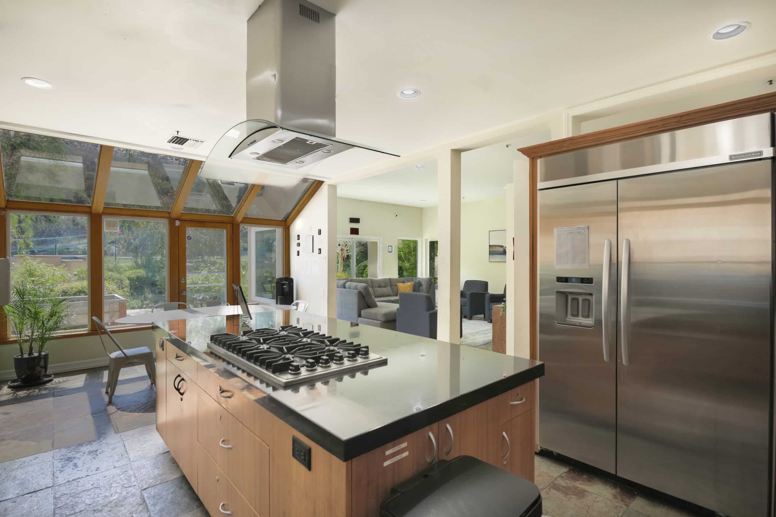 Open kitchen with island cooktop and large windows