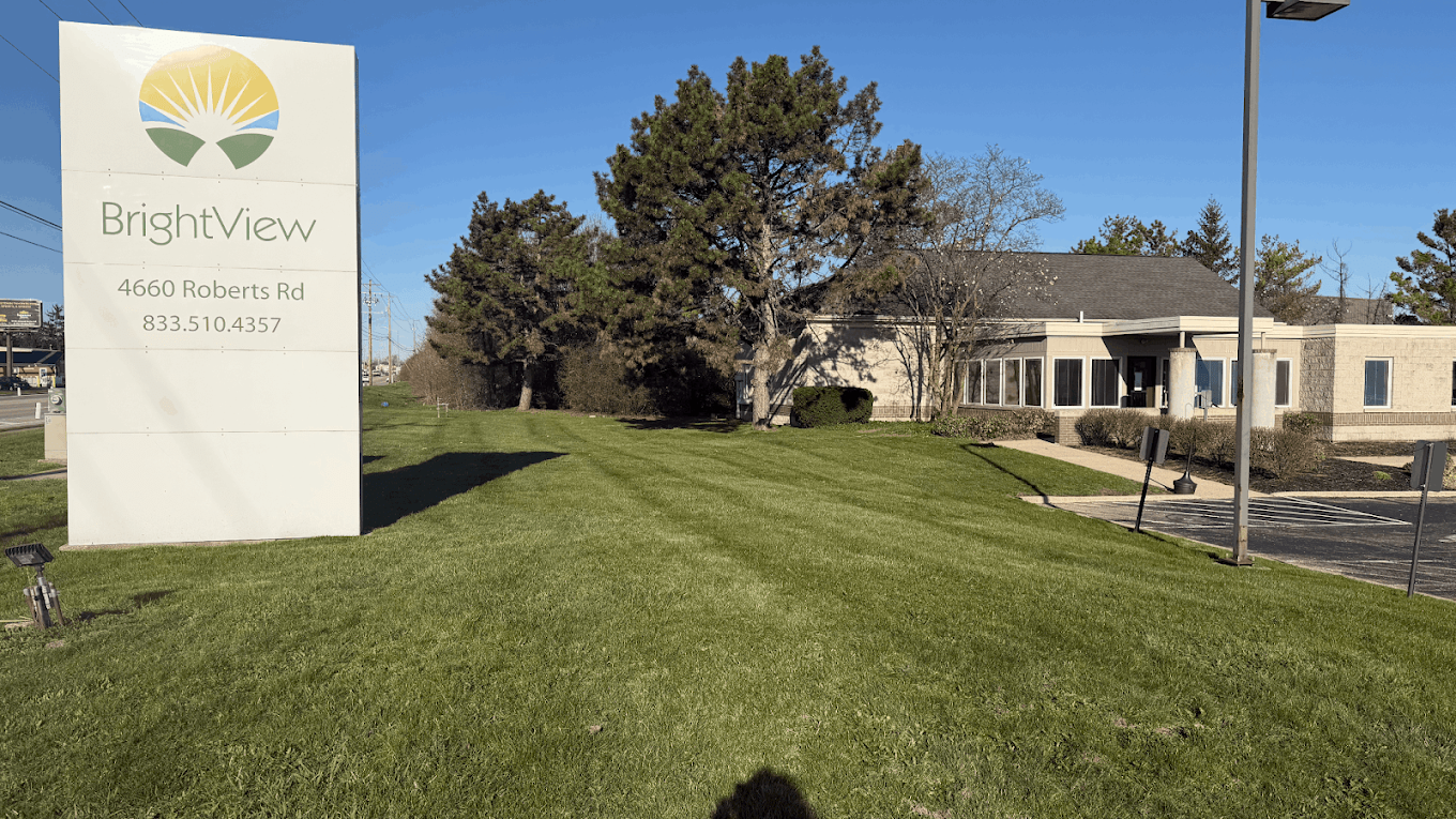 BrightView Health Columbus facility exterior with roadside BrightView sign, lawn, trees, and building entrance
