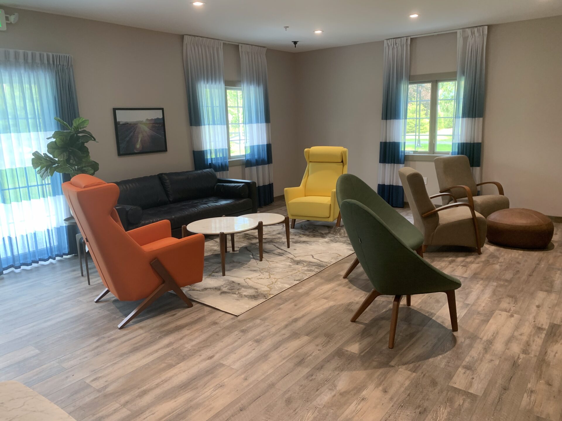 Lounge with black leather couch and colorful chairs