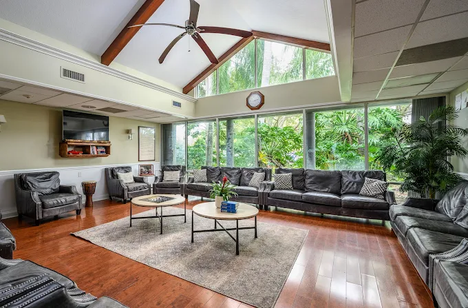 Lounge with sofas, tables, and large windows