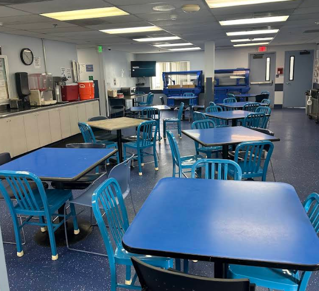 Bright dining hall with blue tables and chairs