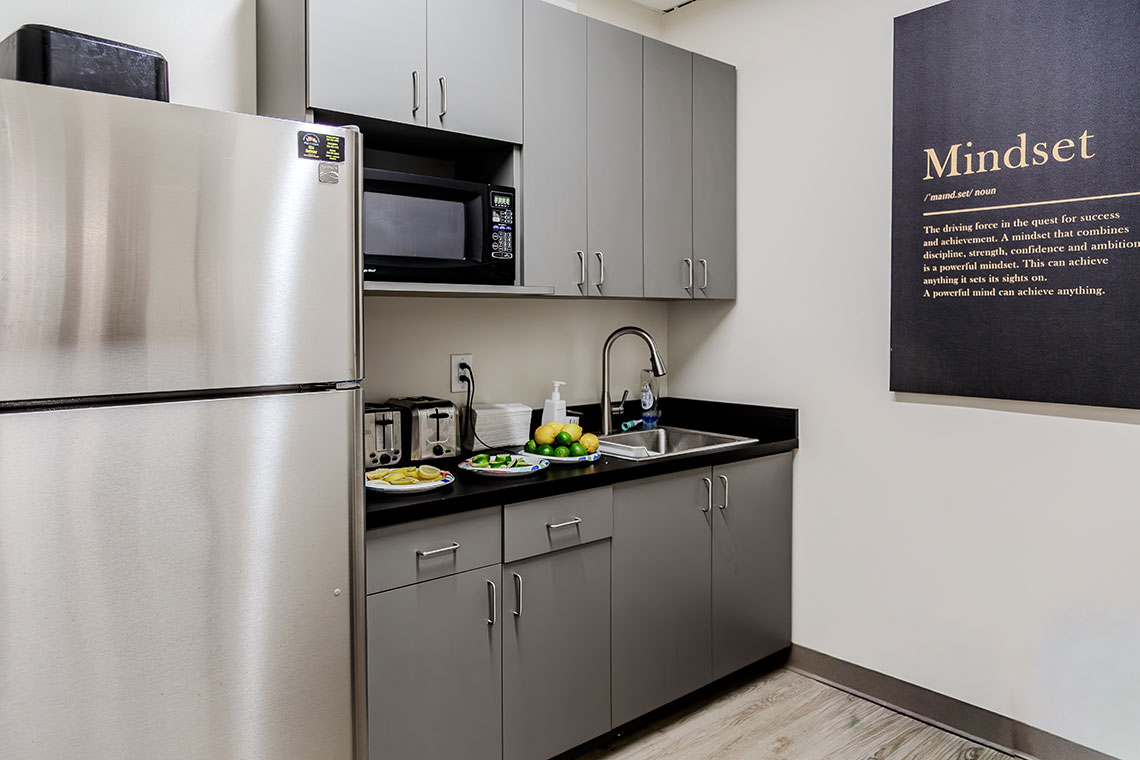 Kitchen area with refrigerator, cabinets, and sink