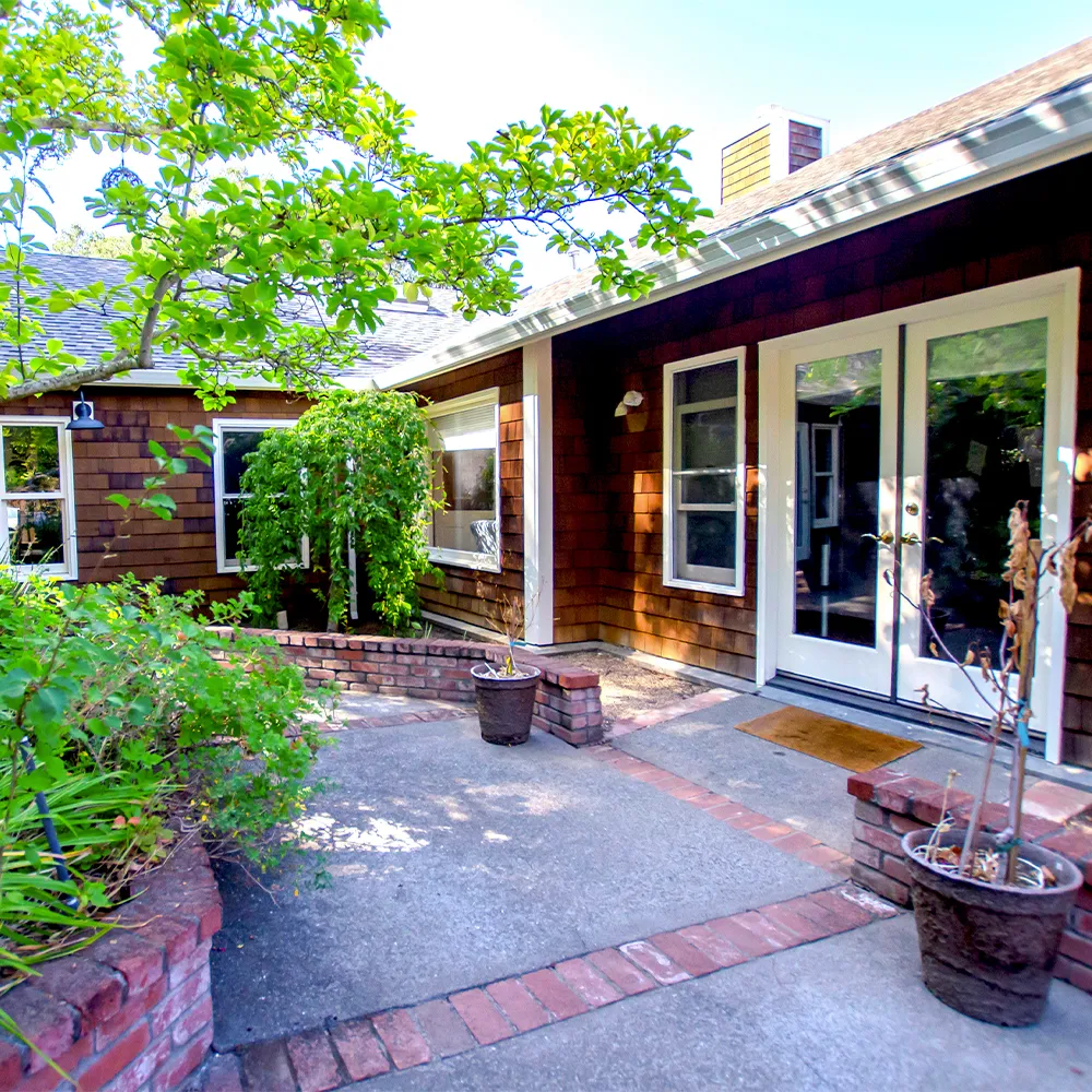 Facility entrance with brick walkway and greenery