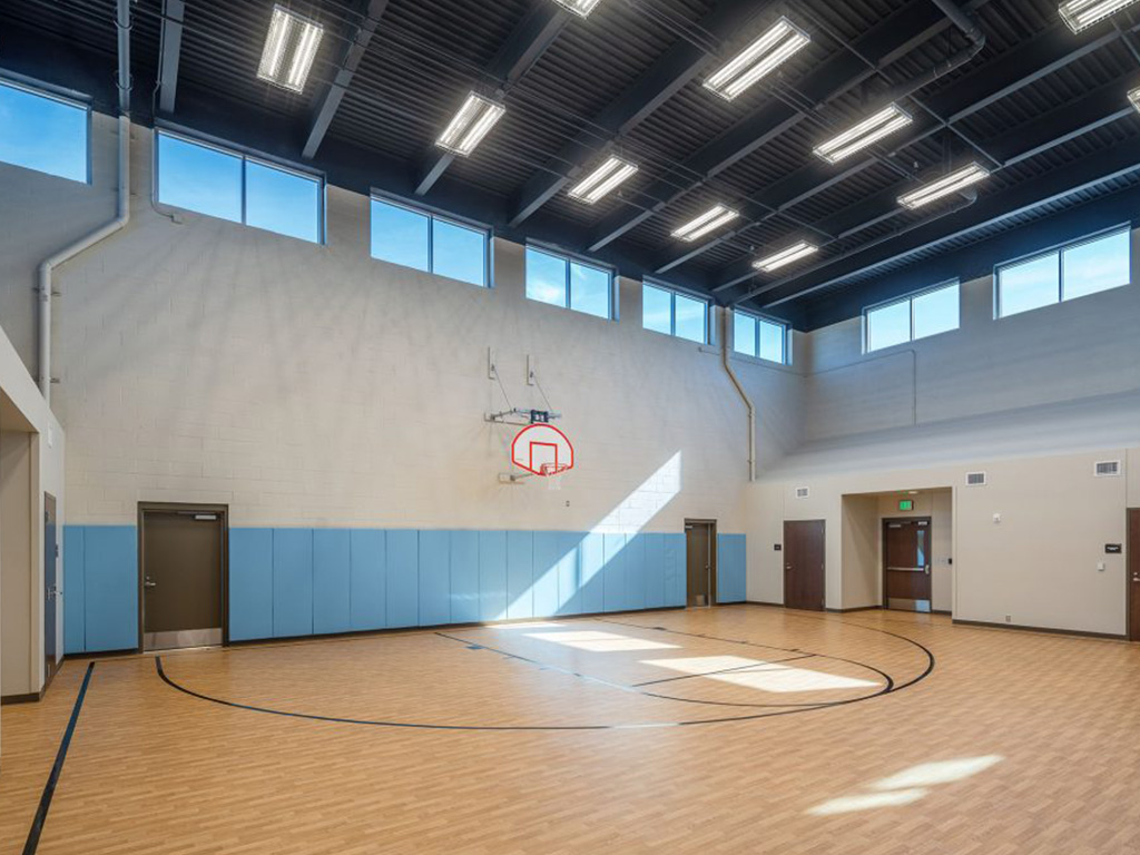 Indoor basketball court with high ceilings and hoop