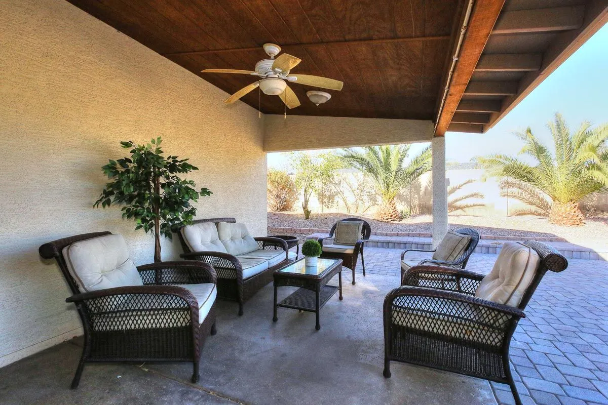 Covered outdoor seating area overlooking the landscaped backyard at the Phoenix residence