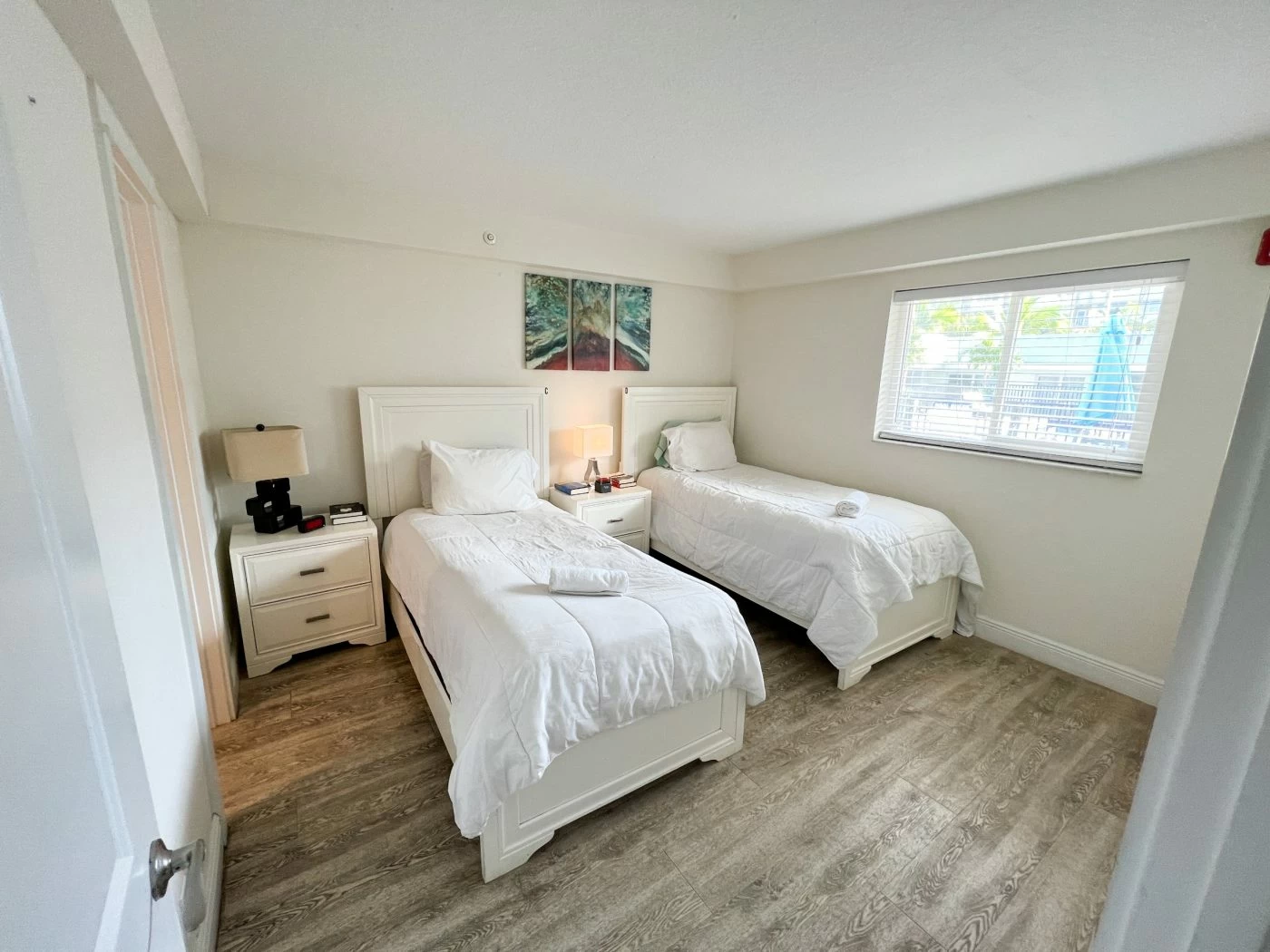 Resident bedroom with two twin beds, bedside table, and natural light