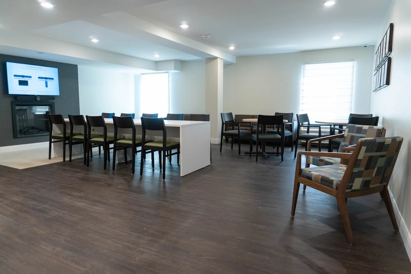 Communal room with tables, chairs, television, and fireplace