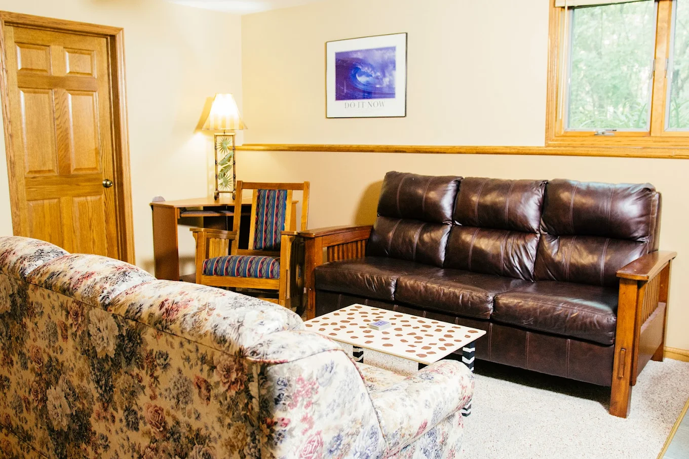 Cozy sitting room with sofas, desk, and warm lighting