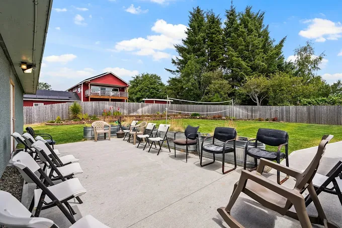 Patio with chairs and grassy fenced yard