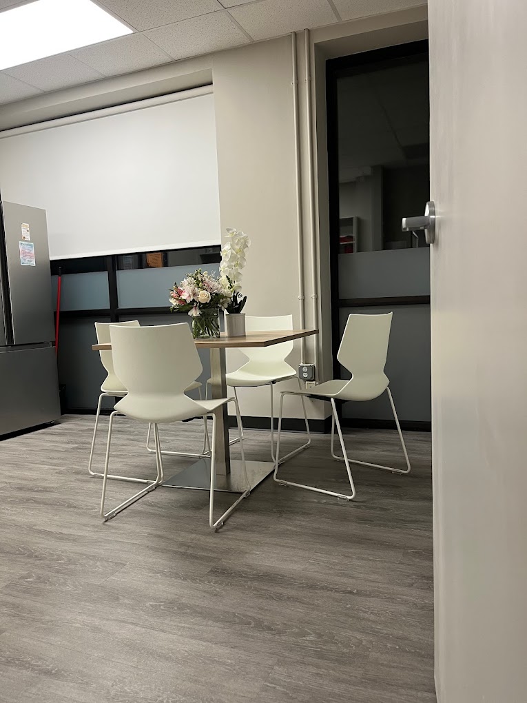 A small dining area with a table and white chairs.