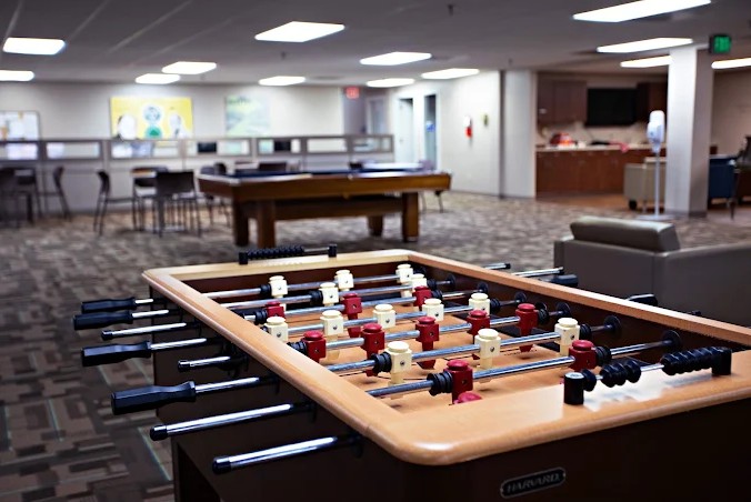 Foosball table in a spacious rehab facility lounge area