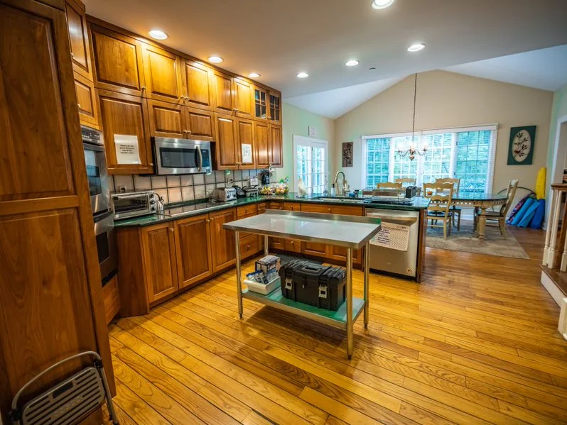 Full kitchen with wood cabinets, island, and dining area