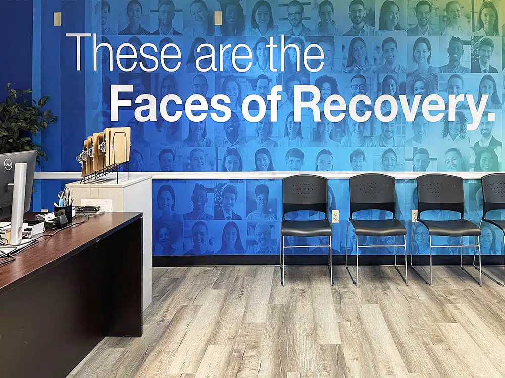 Chairs in waiting area with Faces of Recovery wall mural