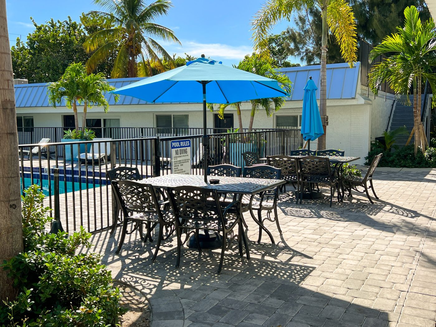 Outdoor patio seating with umbrellas beside the residential treatment center pool