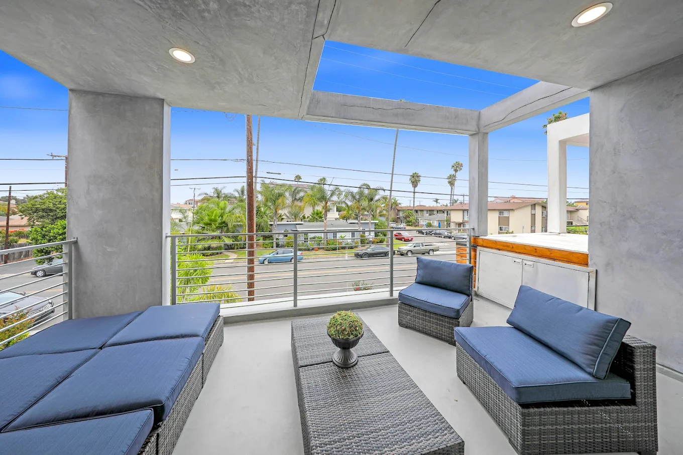Covered patio with wicker seating and street view