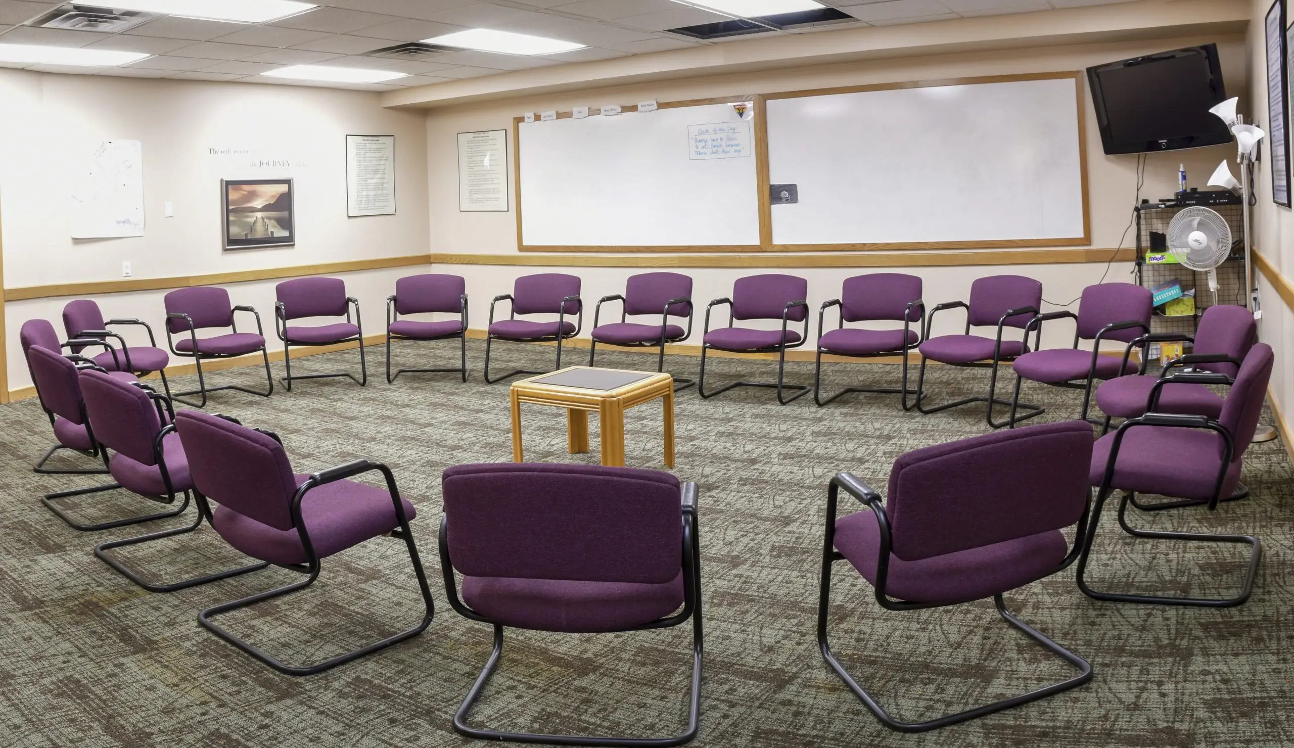Circle of purple chairs in therapy meeting room