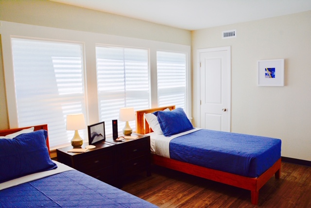 Shared bedroom with twin beds and large windows