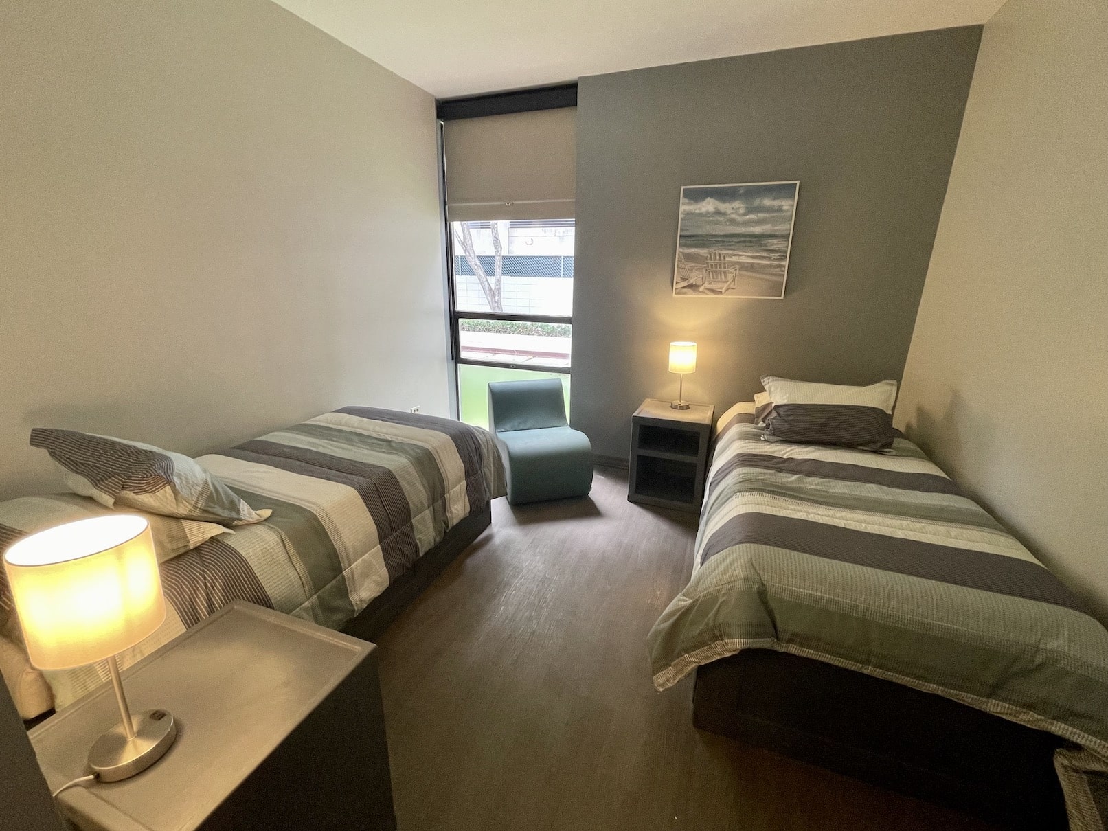 Shared room with two twin beds, lamps, and modern decor