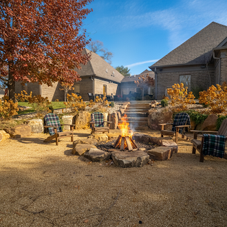Fire pit area with chairs and autumn landscaping.