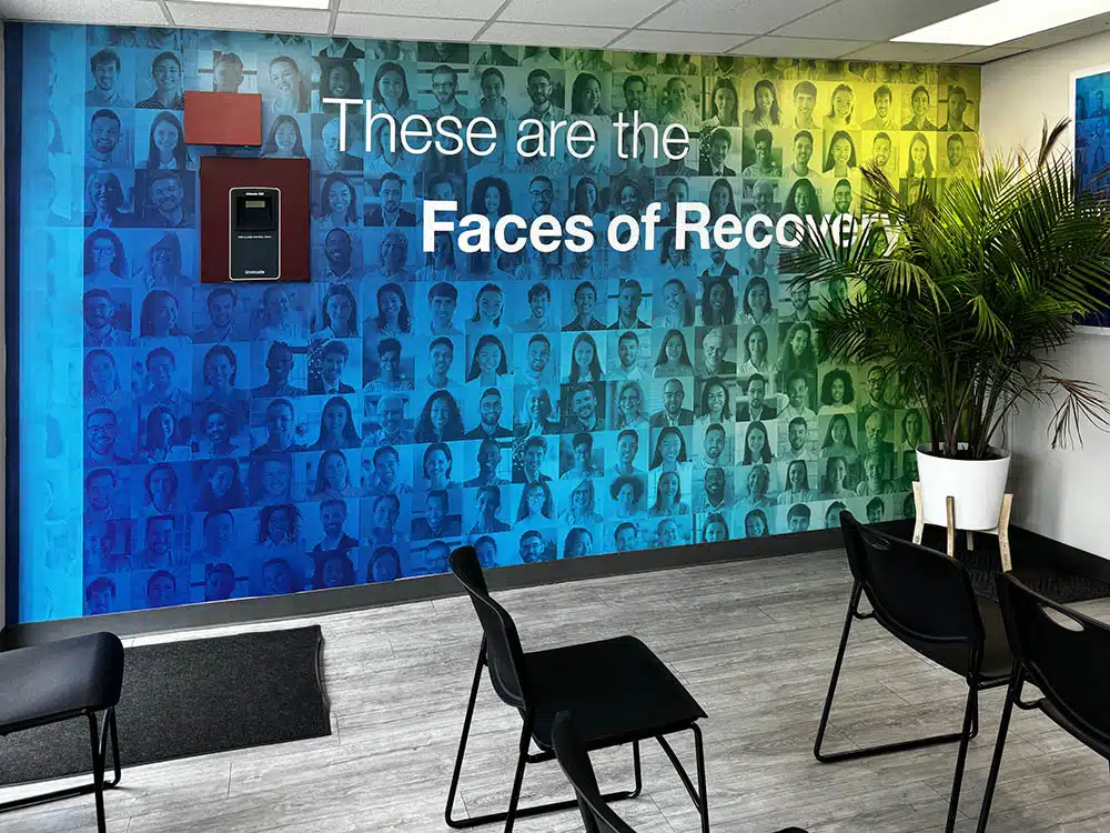 Waiting area with chairs and colorful Faces of Recovery wall