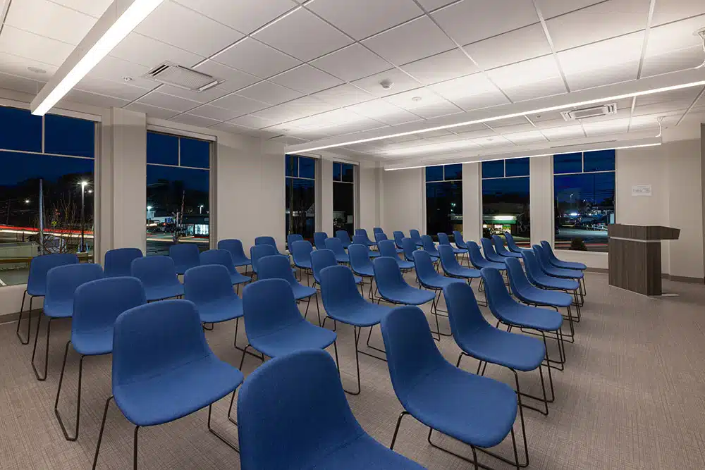 Meeting room with rows of blue chairs and podium