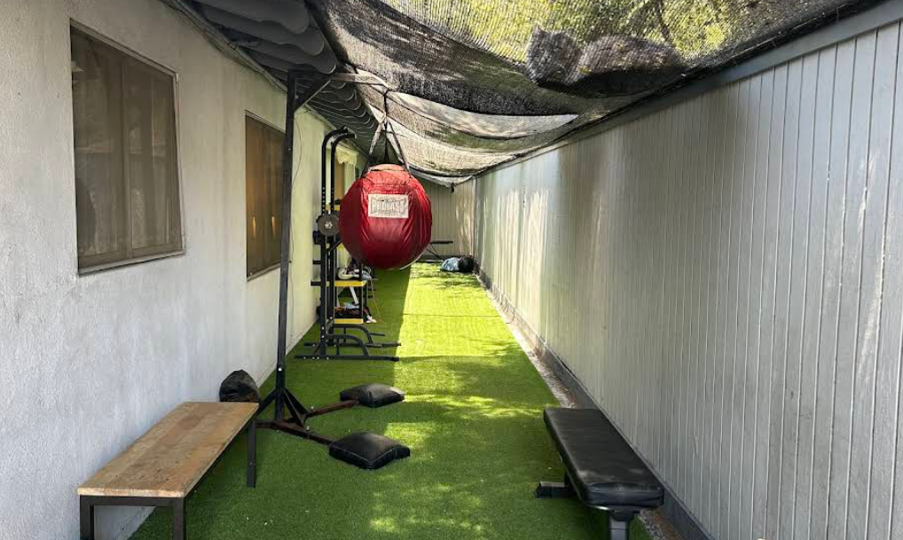 Outdoor gym with punching bag, bench, and turf flooring