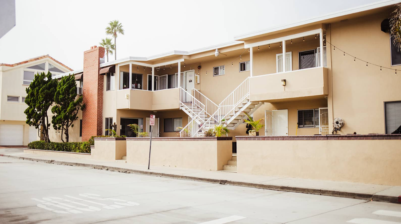 Beige two-story rehab building with white stairs and patio